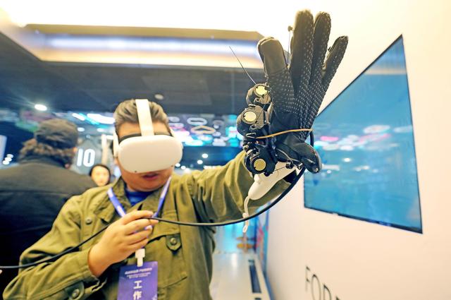 2023年3月21日，杭州，观众在中国虚拟现实与元宇宙产业峰会上体验人机交互触觉手套。IC 图